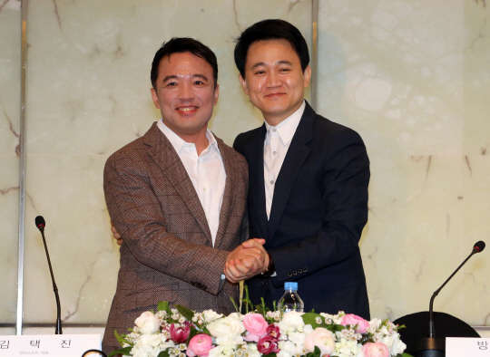 김택진 엔씨소프트 대표(왼쪽)와 방준혁 넷마블게임즈 의장이 지난 17일 서울 중구 플라자호텔에서 열린 공동사업과 전략적 제휴식에서 손을 맞잡고 있다. <연합뉴스>